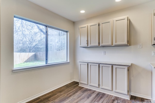 interior space with light countertops, dark wood finished floors, and baseboards