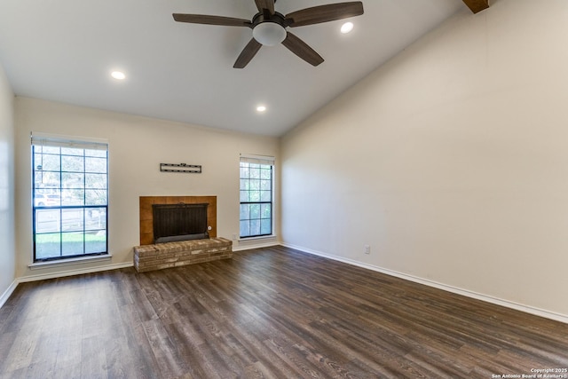 unfurnished living room with lofted ceiling, recessed lighting, baseboards, a brick fireplace, and dark wood finished floors