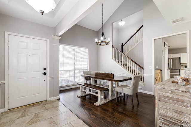 dining space featuring visible vents, stairway, wood finished floors, vaulted ceiling, and a notable chandelier