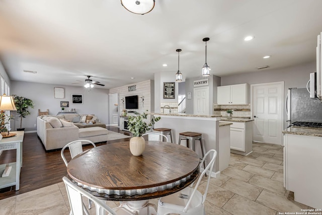 dining room featuring a ceiling fan, recessed lighting, visible vents, and stairway