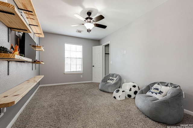 living area featuring ceiling fan, carpet, visible vents, and baseboards