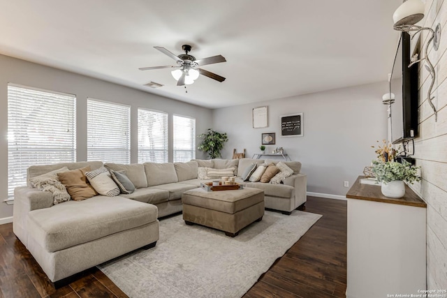 living area featuring visible vents, dark wood finished floors, a ceiling fan, and baseboards