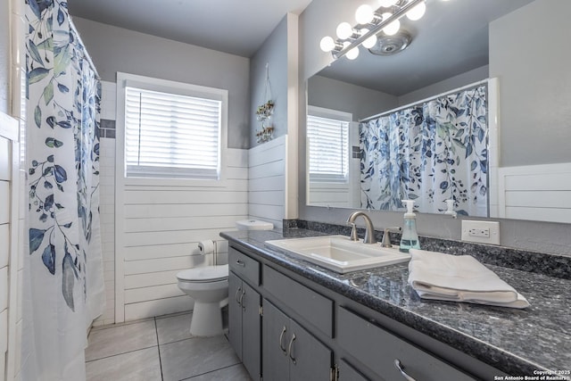 full bathroom featuring toilet, plenty of natural light, tile patterned flooring, and vanity