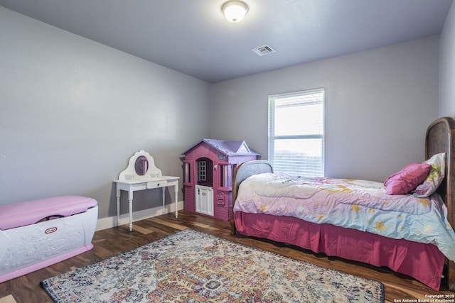 bedroom featuring visible vents and dark wood finished floors