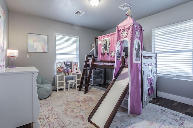 bedroom with visible vents, baseboards, and multiple windows