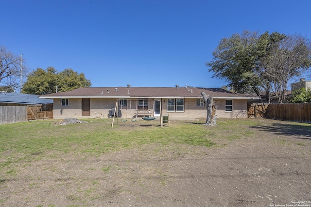 rear view of property featuring a fenced backyard and a yard