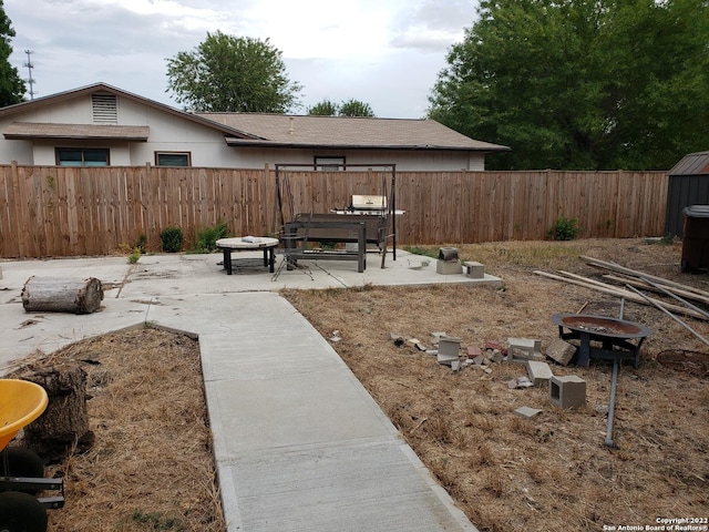 view of yard with a fenced backyard, a patio, and a fire pit