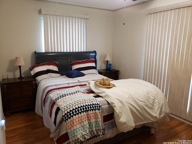 bedroom with crown molding and wood finished floors