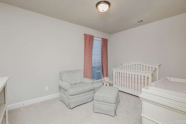 bedroom with baseboards, visible vents, and light colored carpet