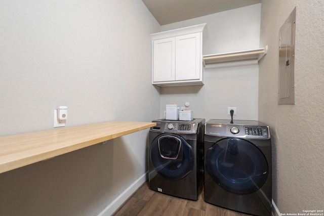 laundry area featuring cabinet space, dark wood-type flooring, electric panel, independent washer and dryer, and baseboards