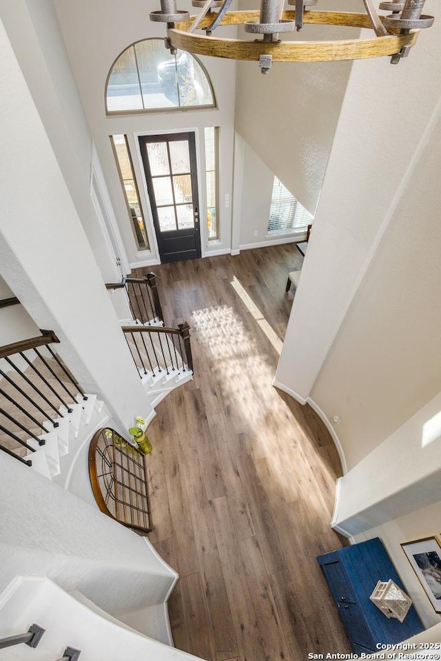 entryway with a healthy amount of sunlight, a high ceiling, stairway, and dark wood finished floors