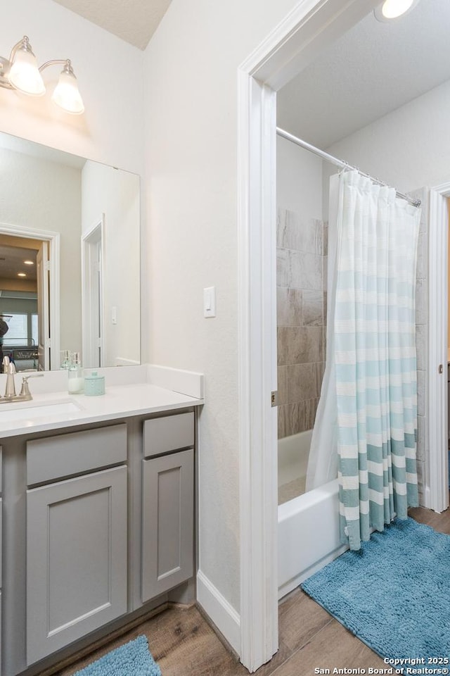 full bath featuring shower / bathtub combination with curtain, vanity, and wood finished floors