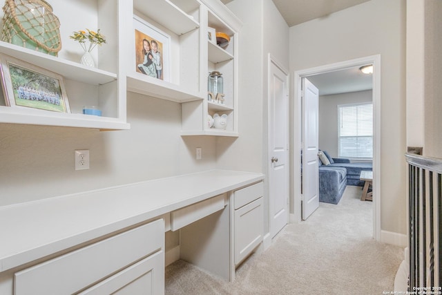 office space featuring built in desk and light colored carpet