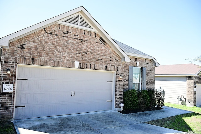 view of front of property with an attached garage, driveway, and brick siding