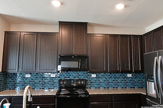 kitchen with decorative backsplash, dark brown cabinetry, black appliances, and light stone countertops