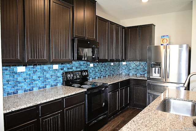 kitchen with decorative backsplash, dark wood-type flooring, a sink, dark brown cabinets, and black appliances