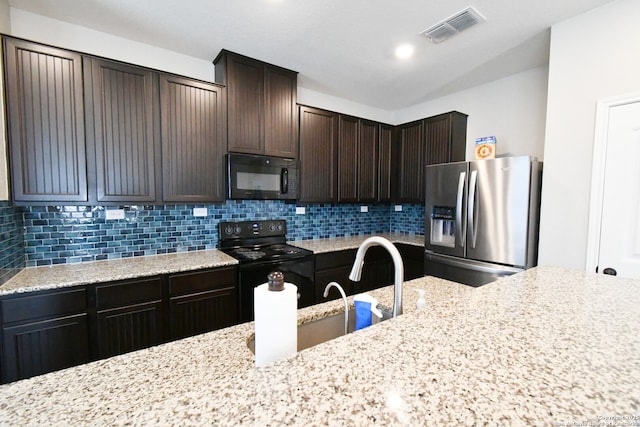 kitchen featuring visible vents, dark brown cabinets, backsplash, and black appliances