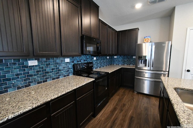 kitchen featuring black appliances, dark wood-type flooring, dark brown cabinetry, and decorative backsplash