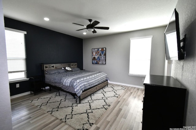 bedroom with light wood finished floors, ceiling fan, baseboards, and recessed lighting