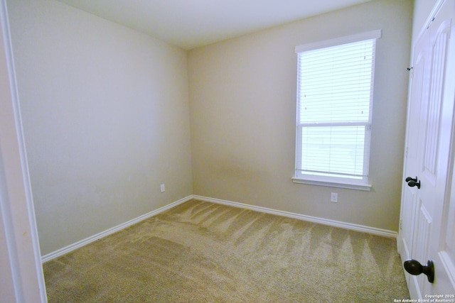 spare room featuring carpet floors and baseboards