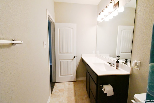 bathroom with baseboards, vanity, toilet, and tile patterned floors