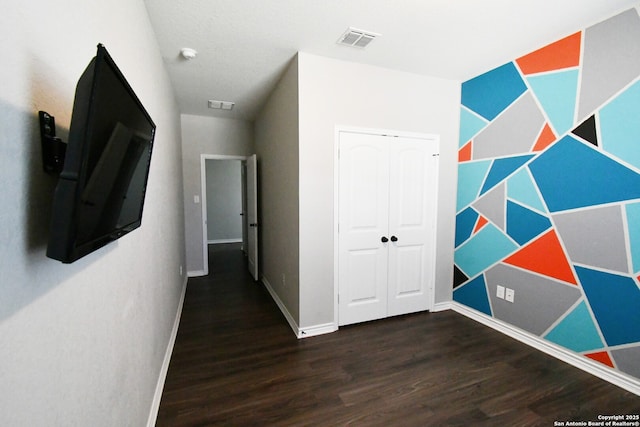 hall with baseboards, visible vents, and dark wood finished floors