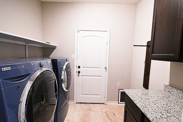 laundry area with baseboards, light tile patterned flooring, cabinet space, and washer and dryer