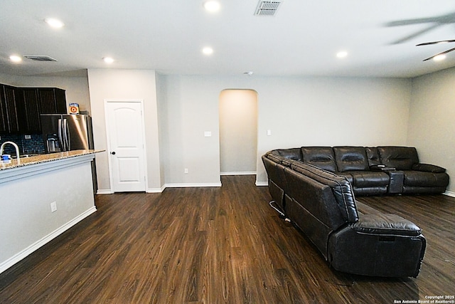 living room featuring recessed lighting, dark wood-style flooring, and visible vents