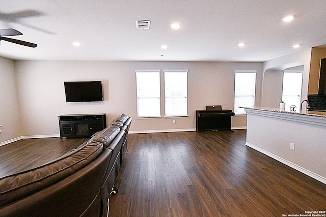 unfurnished living room with dark wood-style floors, a sink, visible vents, and recessed lighting