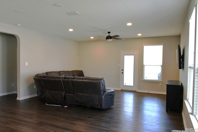 living area featuring arched walkways, dark wood-style flooring, baseboards, and recessed lighting