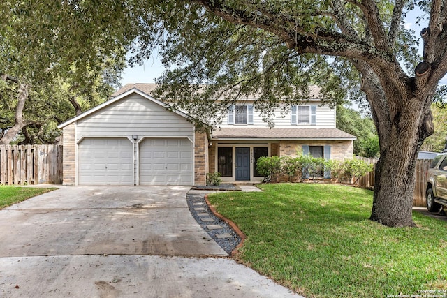 traditional-style home featuring an attached garage, brick siding, fence, concrete driveway, and a front yard