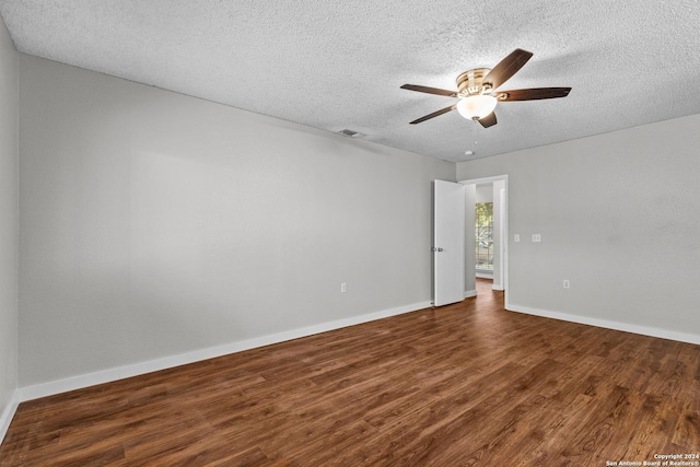 empty room featuring ceiling fan, a textured ceiling, visible vents, baseboards, and dark wood-style floors