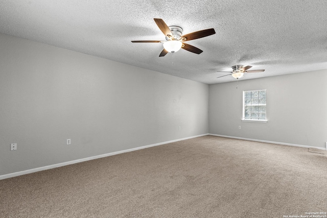 empty room with a ceiling fan, carpet, a textured ceiling, and baseboards