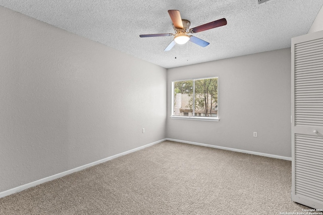 spare room with baseboards, a ceiling fan, a textured wall, carpet, and a textured ceiling