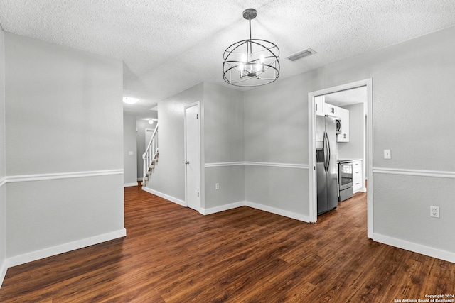 unfurnished room with visible vents, dark wood-type flooring, stairs, a textured ceiling, and a notable chandelier