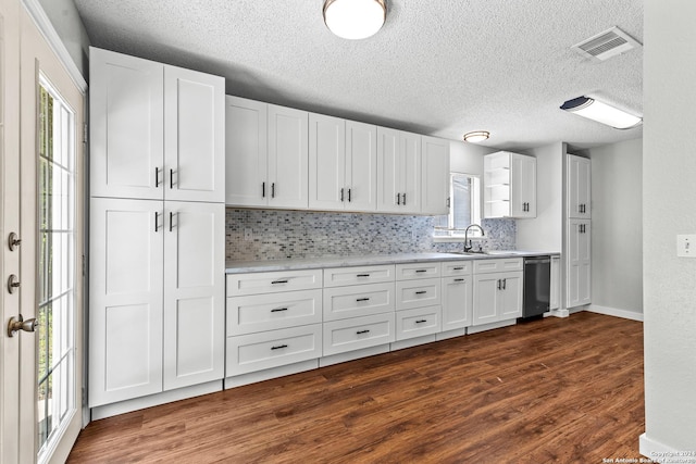 kitchen featuring dark wood finished floors, visible vents, white cabinets, a sink, and dishwasher