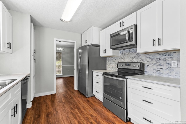 kitchen with stainless steel appliances, tasteful backsplash, dark wood-style flooring, and white cabinetry