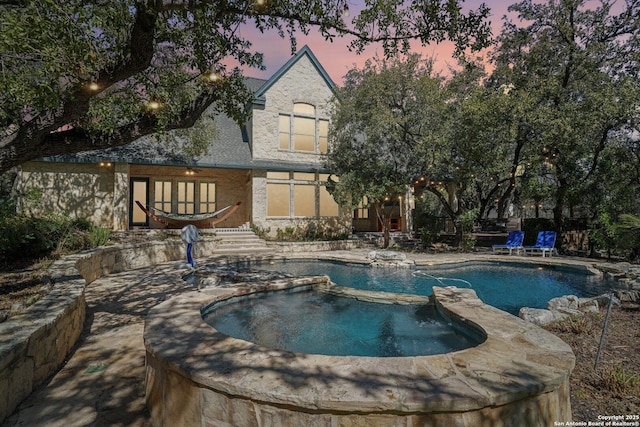 view of pool with a pool with connected hot tub