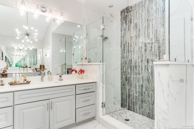 full bathroom featuring vanity, vaulted ceiling, marble finish floor, a marble finish shower, and an inviting chandelier