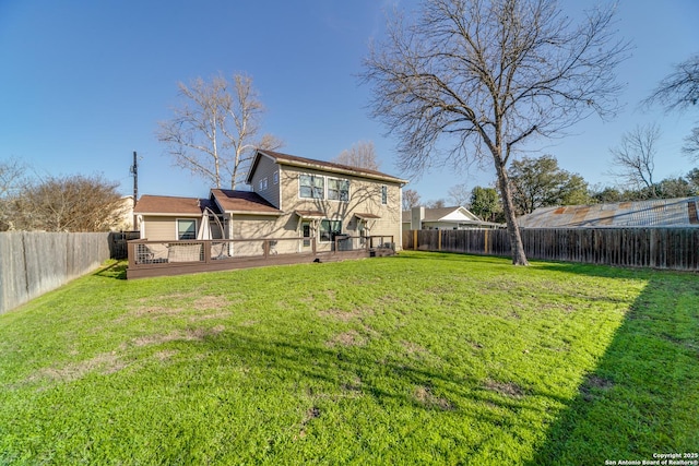 rear view of house featuring a fenced backyard, a yard, and a wooden deck