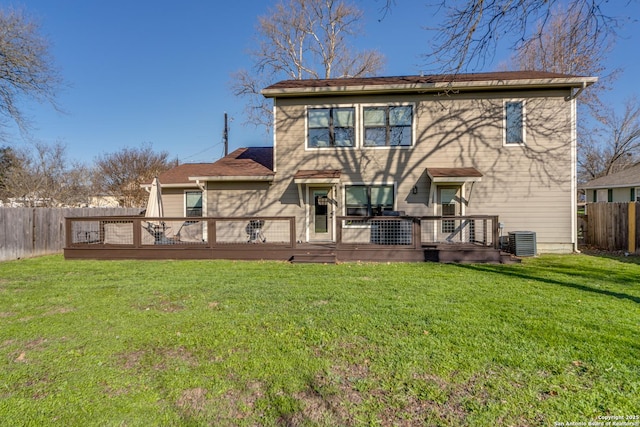 rear view of house with central air condition unit, a yard, a wooden deck, and fence