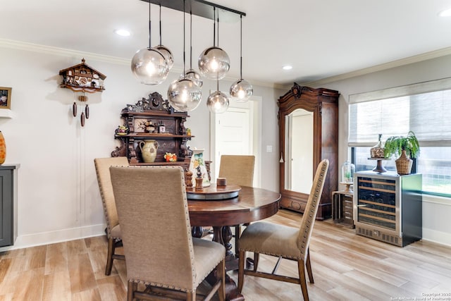 dining space featuring baseboards, ornamental molding, and light wood-style floors