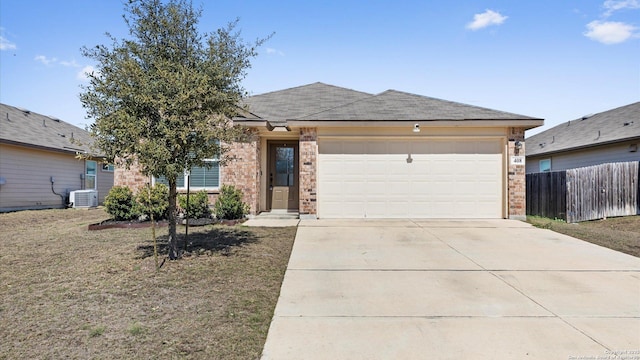 single story home with central AC unit, an attached garage, brick siding, fence, and concrete driveway