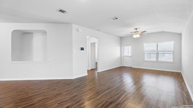 spare room with dark wood-style floors, visible vents, arched walkways, and a ceiling fan