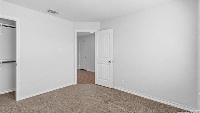 unfurnished bedroom featuring carpet, a closet, visible vents, and baseboards