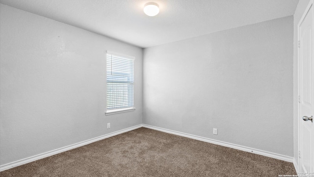 carpeted empty room with baseboards