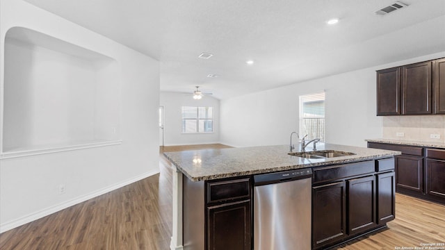 kitchen with visible vents, dishwasher, an island with sink, light wood-style floors, and a sink