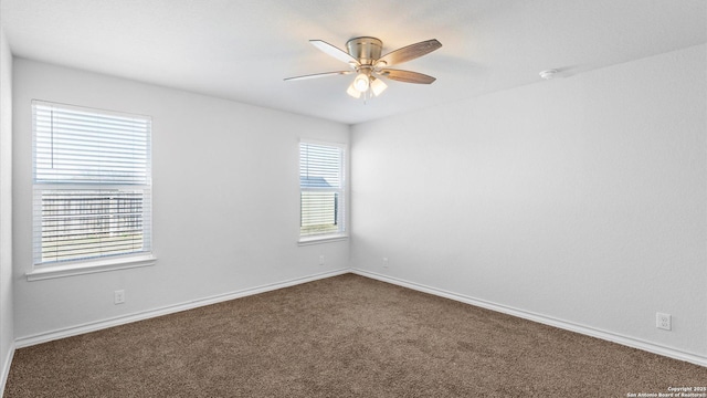 carpeted spare room with ceiling fan and baseboards