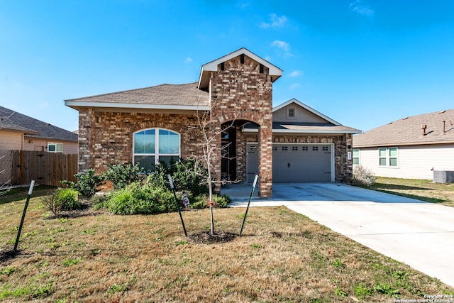 view of front facade with an attached garage, concrete driveway, brick siding, and a front yard