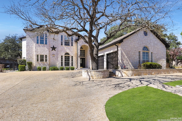 french country inspired facade featuring stone siding and an attached garage